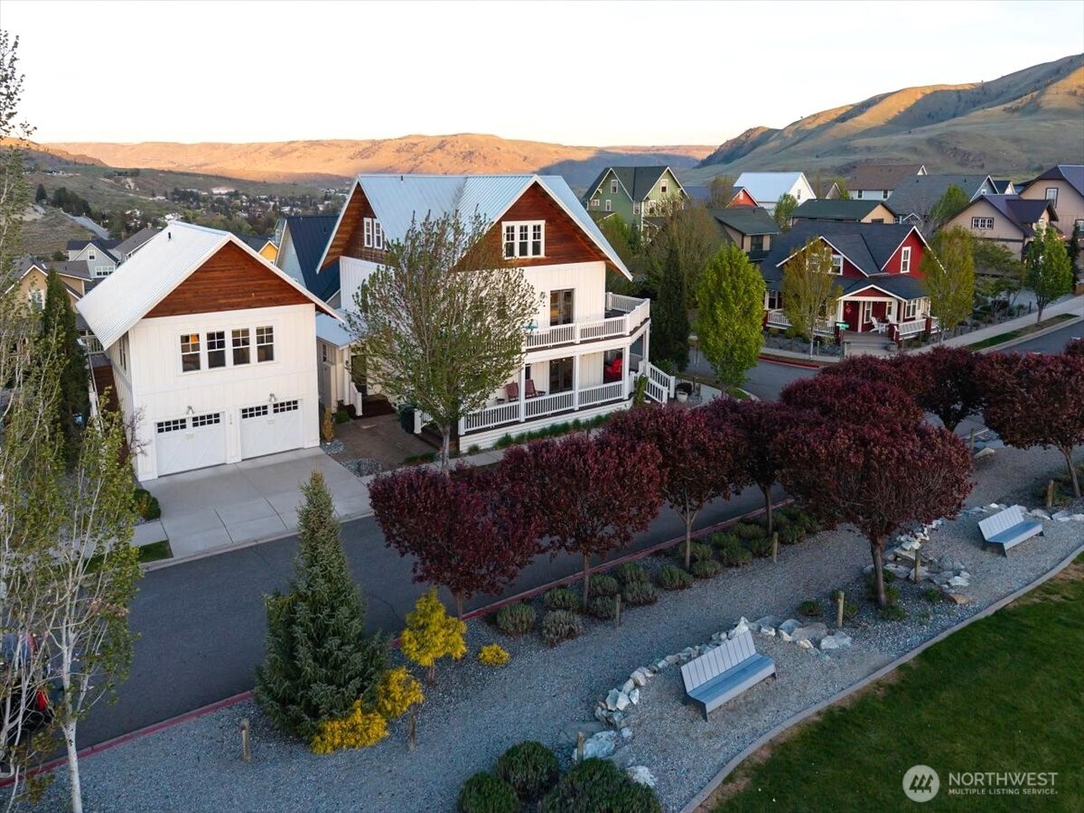 Aerial view of home overlooking the Lookout's Hilltop Park with grassy lawn, playground, outdoor fireplace and BBQ area, pickleball court, clubhouse, pool and hot tub.