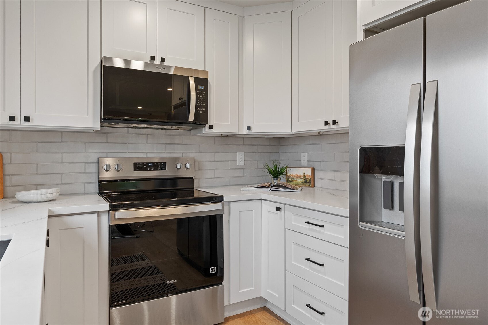 Kitchen has quartz countertops and tile backsplash.