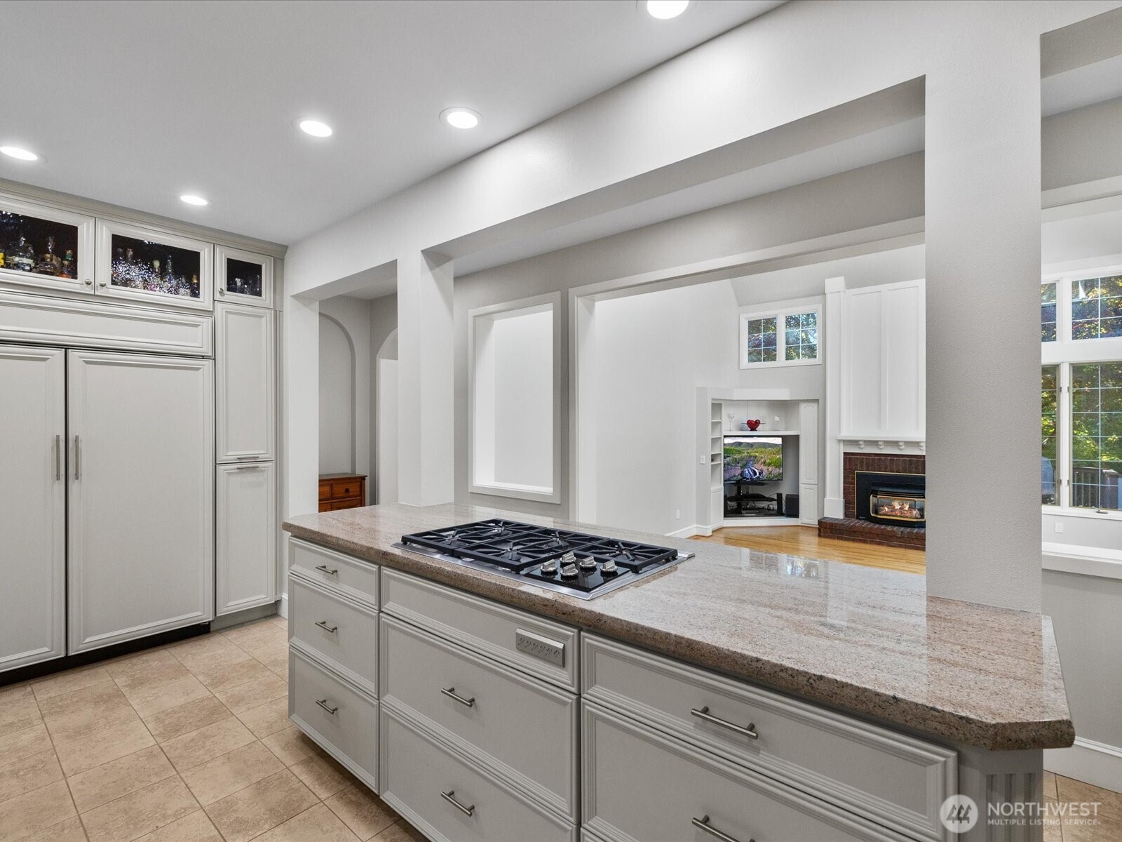 Bright and beautiful kitchen with Wolf stovetop.  Looking into family room.