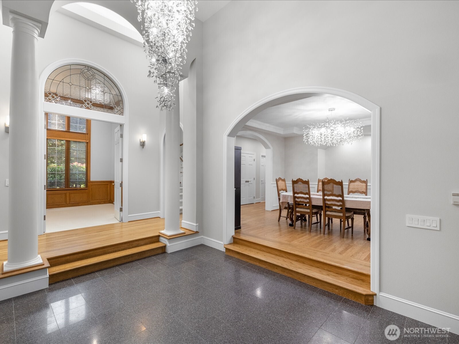 Brilliant chandeliers hang high above.  Huge vaulted ceilings.  Formal and beautiful dining room to the right with new and gorgeous chandelier.  The den/office is to the left and Primary bedroom is to the left of the den.