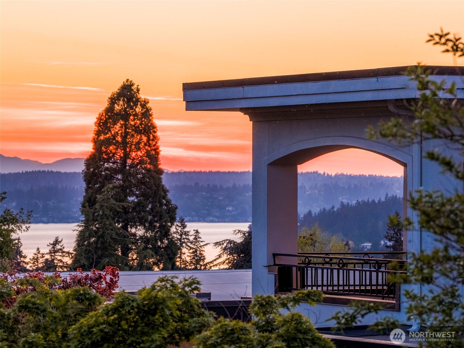 View from Primary bedroom balcony: Captivating sunset view from the Primary Suite's private balcony, framed by graceful archway detailing.