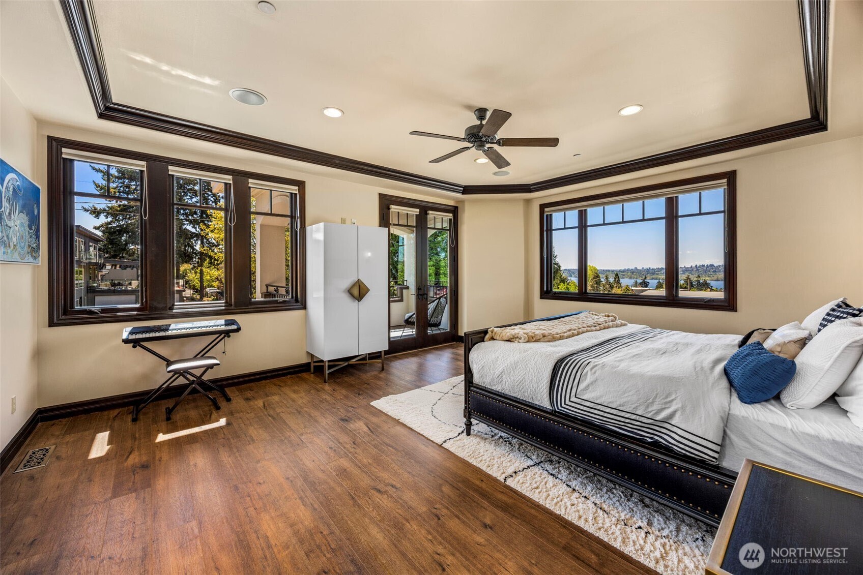 Upper level Primary bedroom with views: Sumptuous Primary Suite with rich flooring, designer ceiling detail, and expansive windows framing the view.