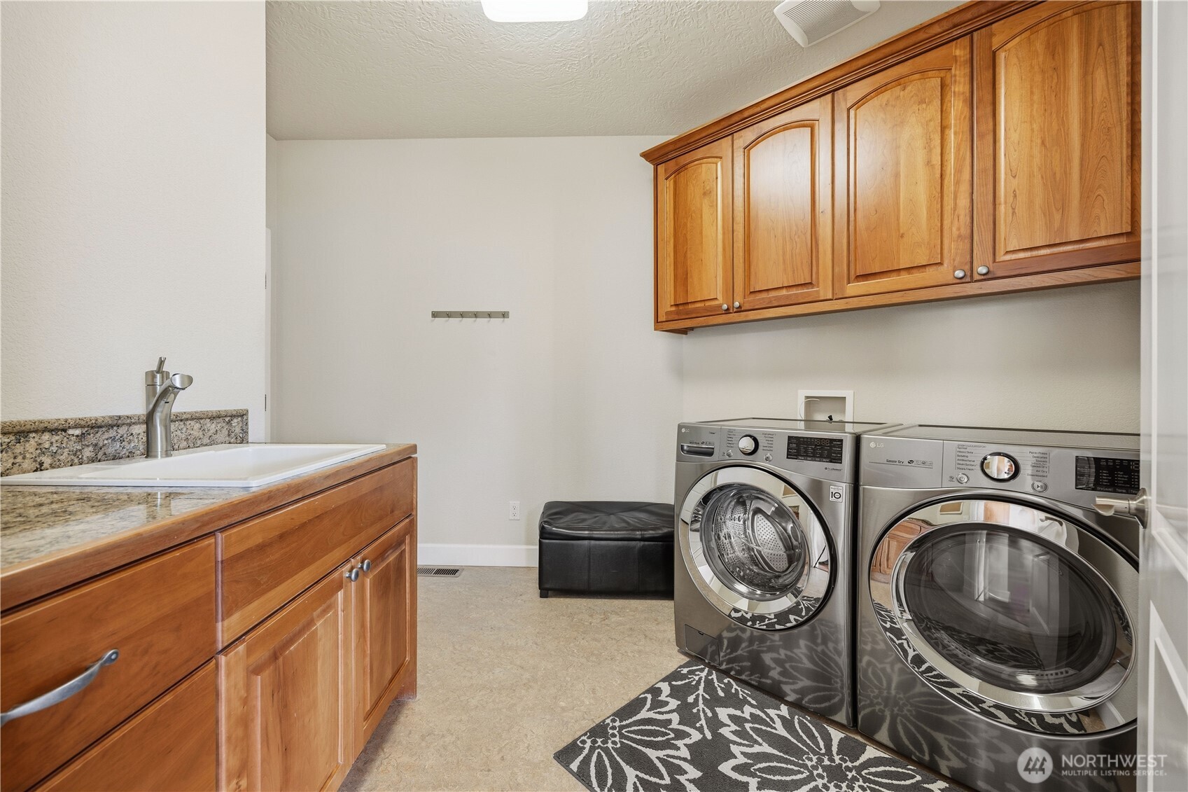 Functional laundry room with ample cabinetry for storage and counter space for folding and organization. This efficient space is designed to make everyday tasks convenient and streamlined.