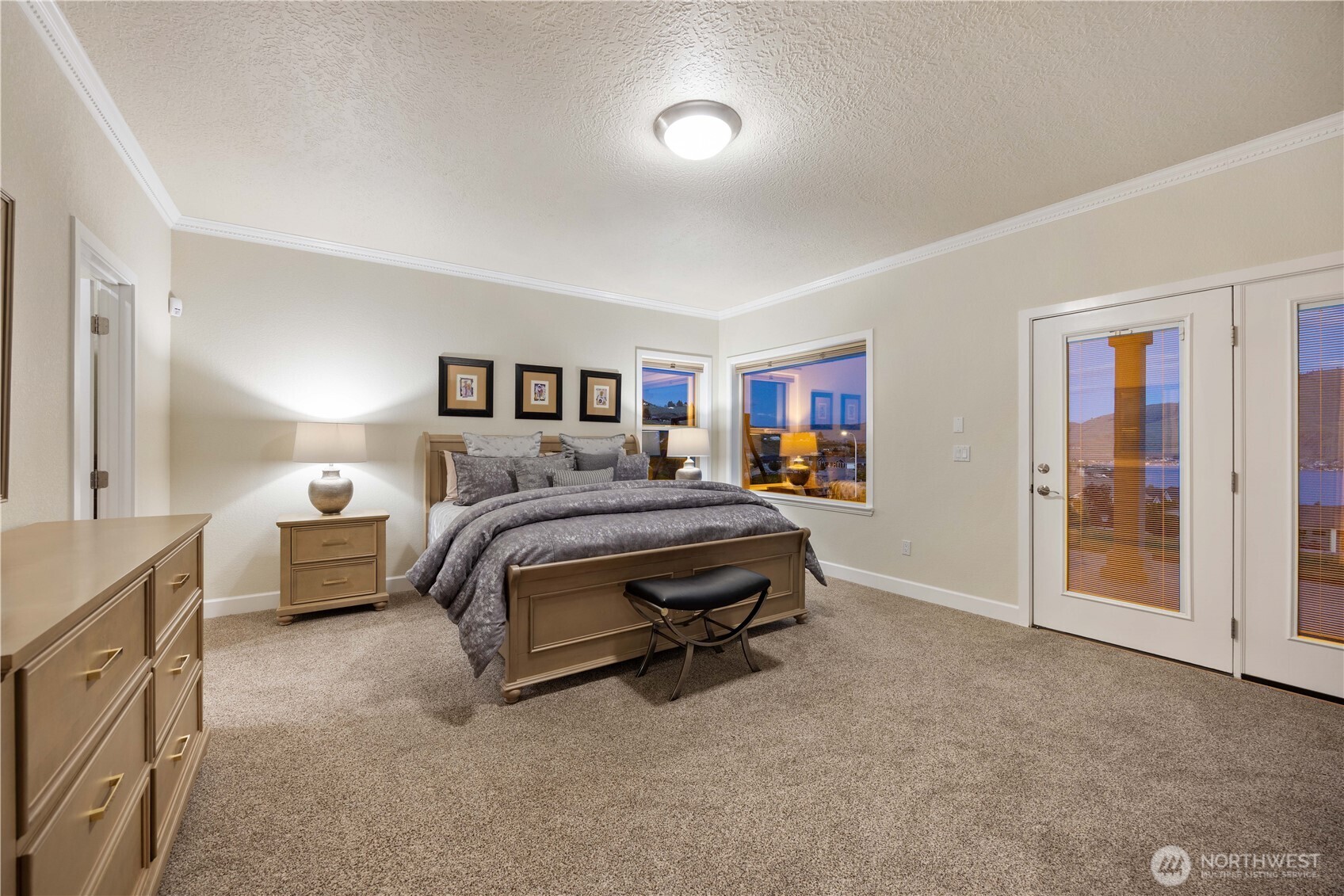 Expansive primary suite offering a peaceful retreat with plush carpeting, ample space for a sitting area, and abundant natural light. Thoughtfully designed with direct access to the en suite bath and walk-in closet, creating a comfortable and functional private sanctuary.