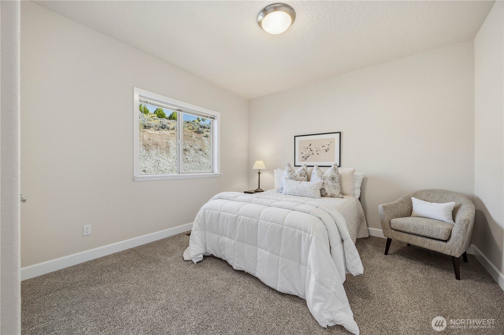 Comfortable guest bedroom featuring soft carpeting, neutral tones, and a bright window that brings in natural light. A welcoming and versatile space perfect for visitors or additional living needs.