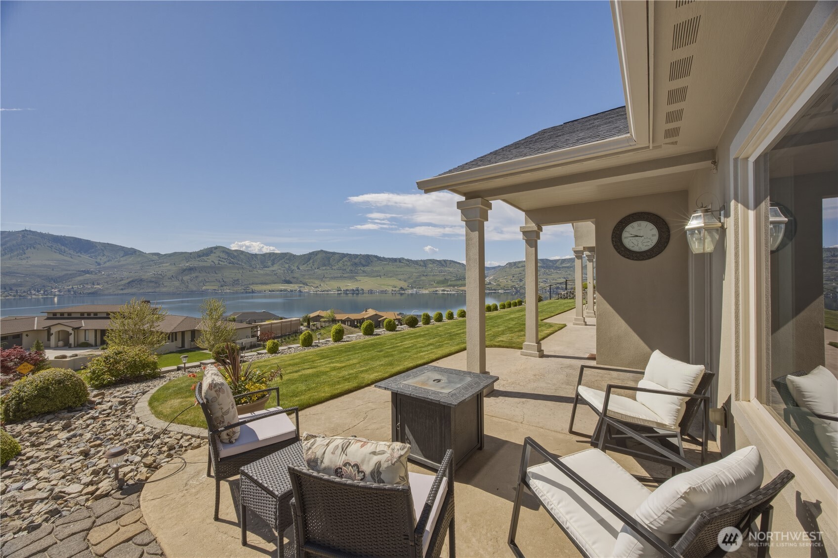 Expansive patio designed for year-round enjoyment with covered and open spcaes, featuring comfortable seating areas and sweeping panoramic views of Lake Chelan, and the surrounding mountains. A perfect setting for relaxing or entertaining while taking in the stunning natural beauty.