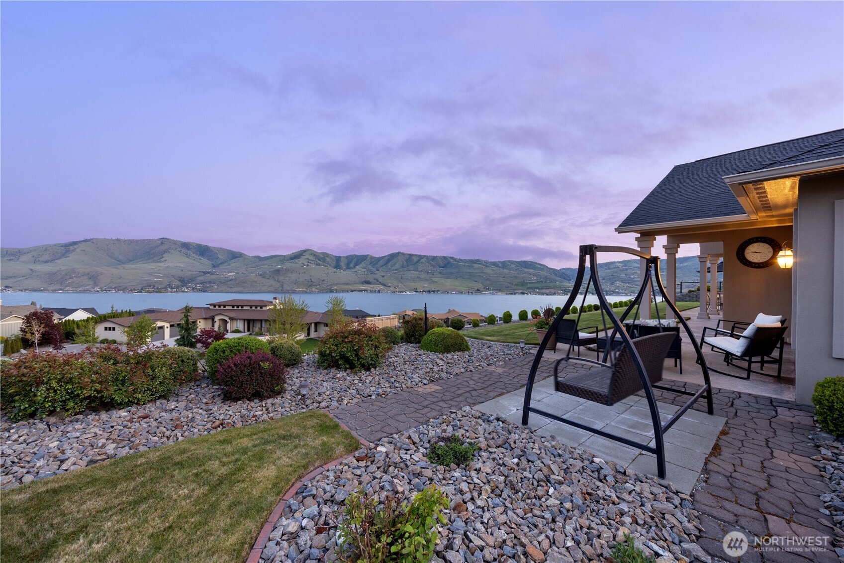 Tranquil outdoor retreat featuring a spacious patio and manicured grounds, perfectly positioned to capture breathtaking sunset views over Lake Chelan and the surrounding mountains. Ideal for relaxing evenings, this serene setting offers a true sense of privacy and connection to the natural beauty.