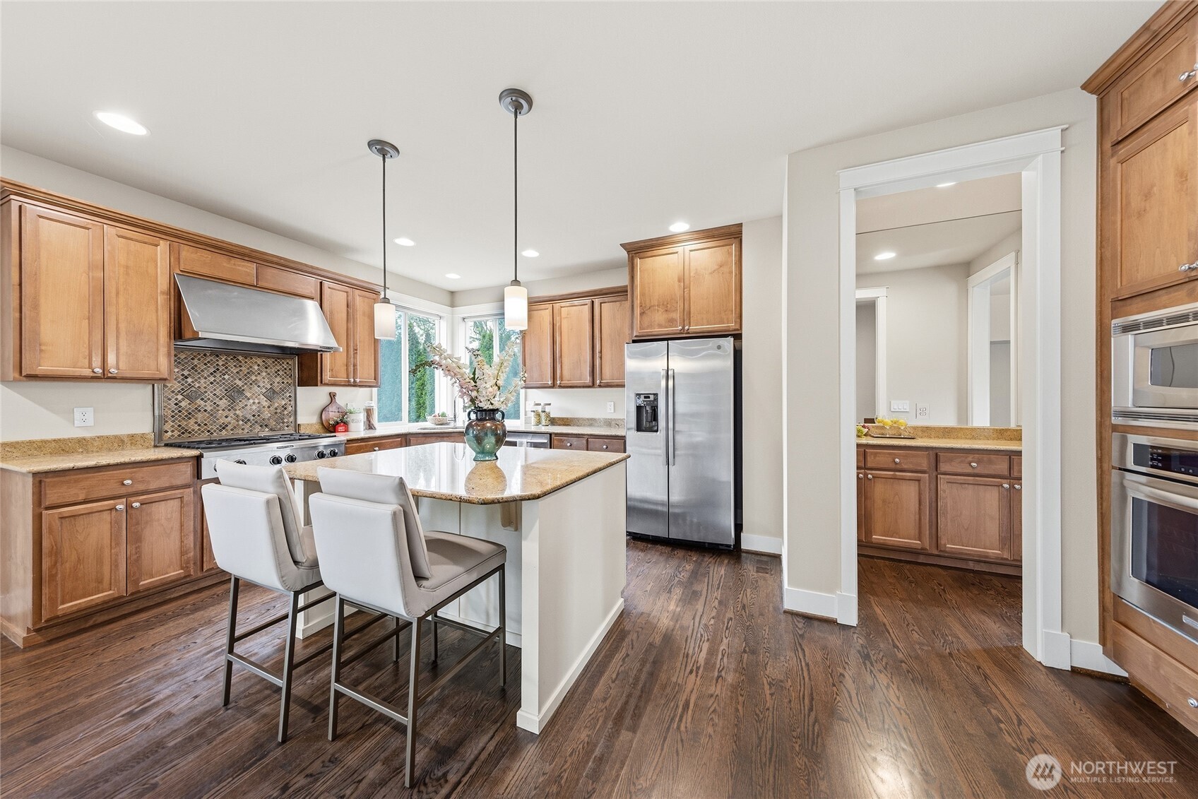 Kitchen with full height tile backsplash and slab granite countertops