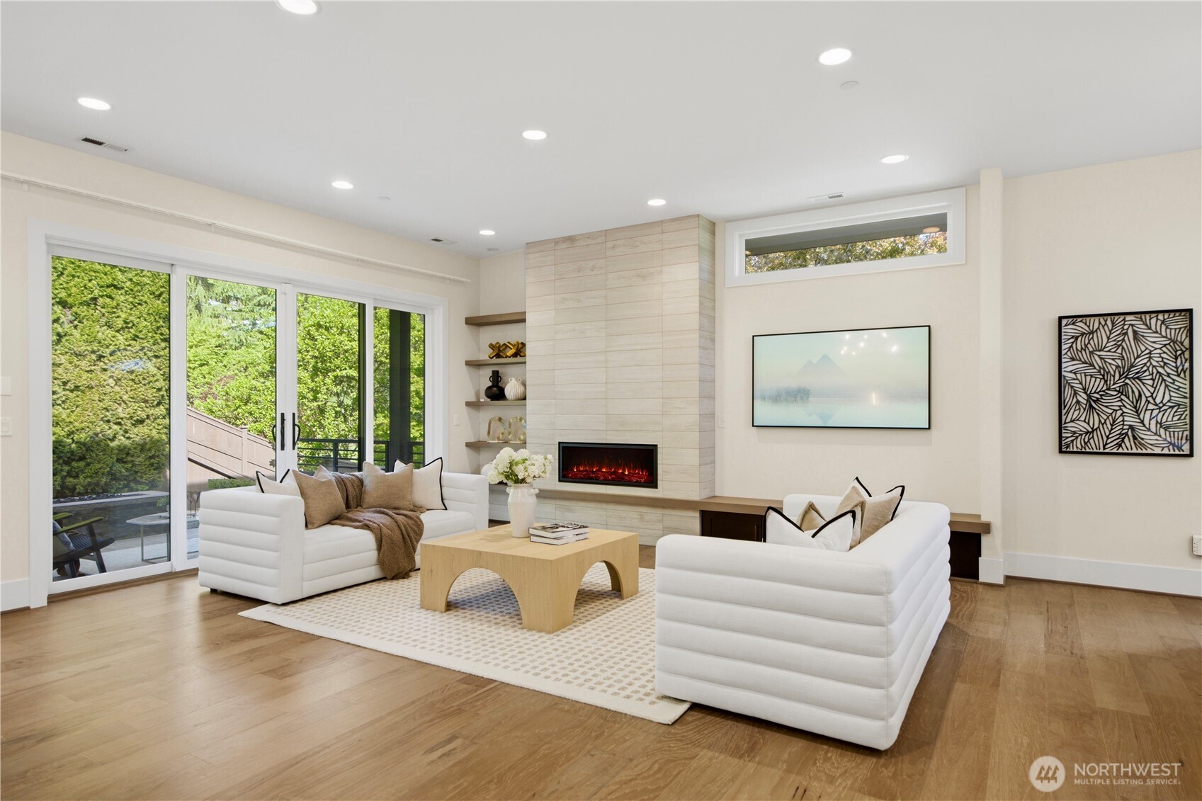 Living room features gas fireplace, tile surround, floating shelves and large sliding glass doors for easy indoor outdoor living