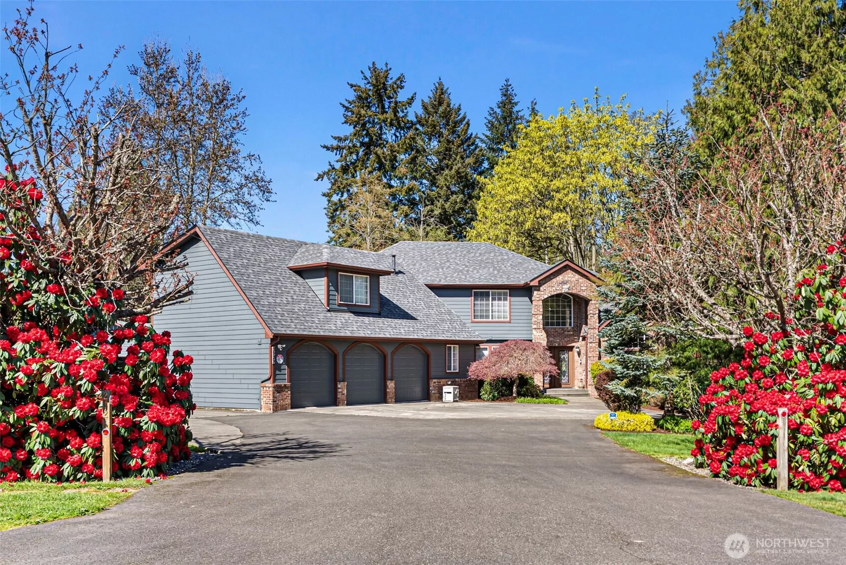 Front Facade with wide Driveway approach and driveway to Detached Garage