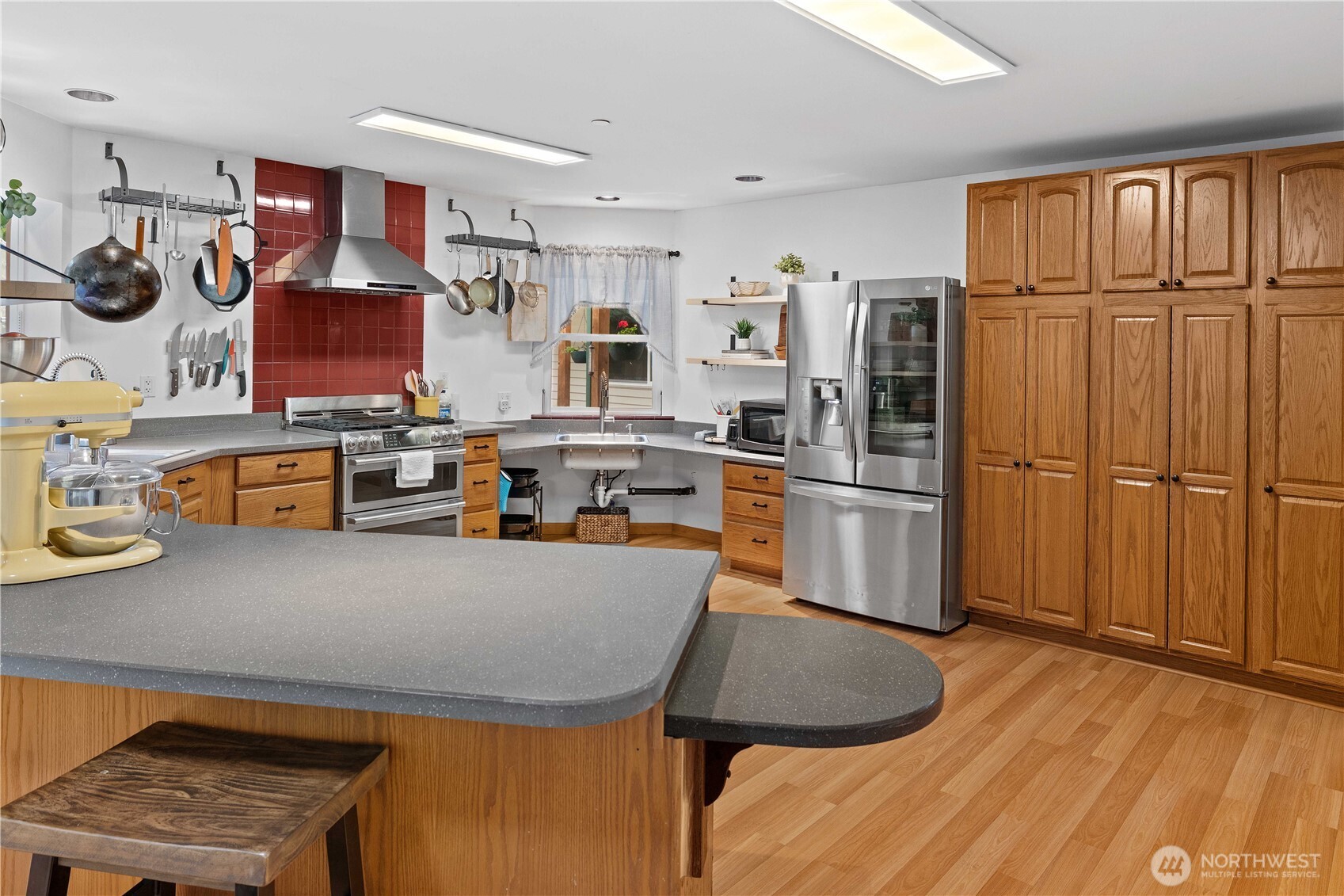 View of breakfast bar and kitchen with built-ins and double ovens