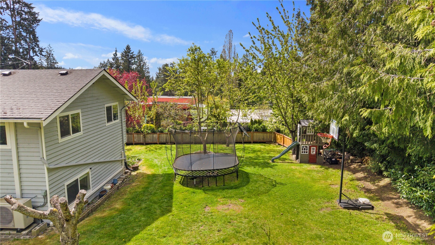 Expansive fenced backyard with mature landscaping, fruit trees, usable lawn space, and room to garden, play, or simply unwind
