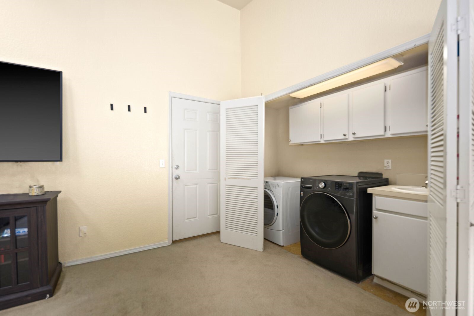 Laundry area with upper cabinetry, utility sink, and washer and dryer connections