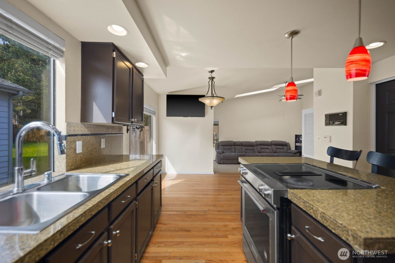 Kitchen and dining area with island seating, pendant lighting, and sliding door access to the backyard