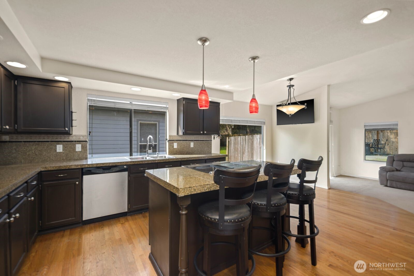 Kitchen featuring extensive cabinetry, double sink, and backyard-facing window for natural light