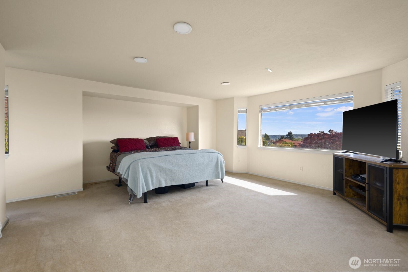 Generous primary bedroom with large windows, natural light, and flexible layout options.