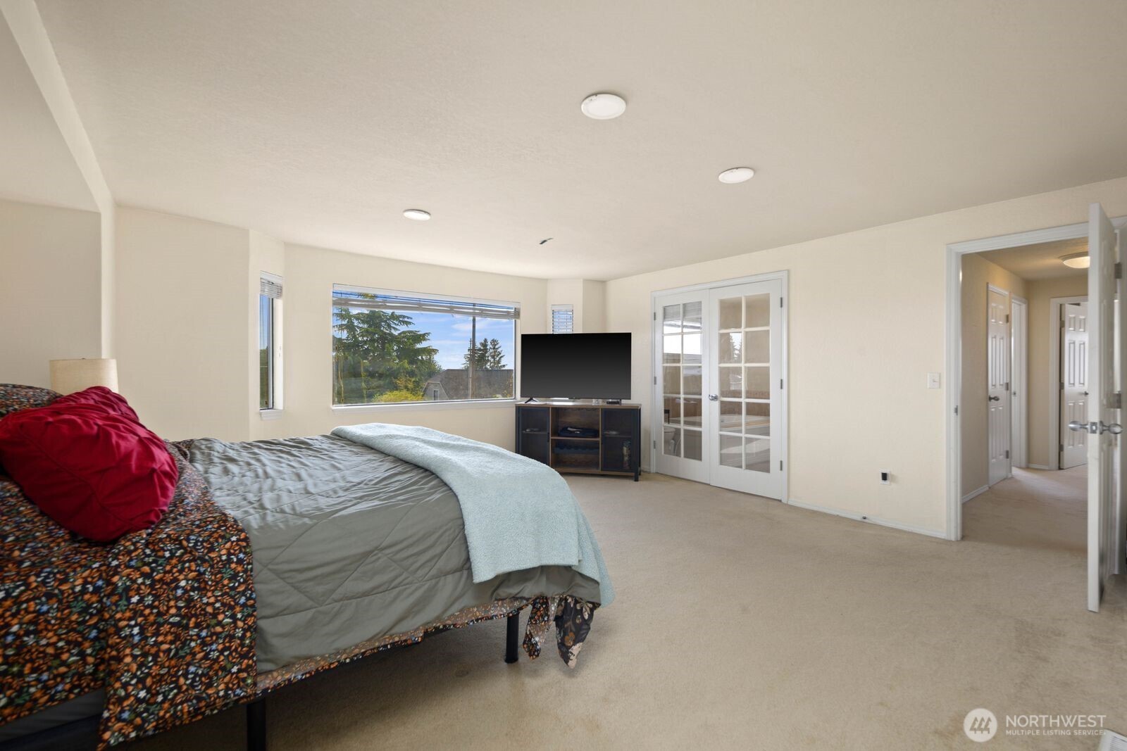 Primary suite with spacious layout, multiple windows, and access to an adjoining room or office.