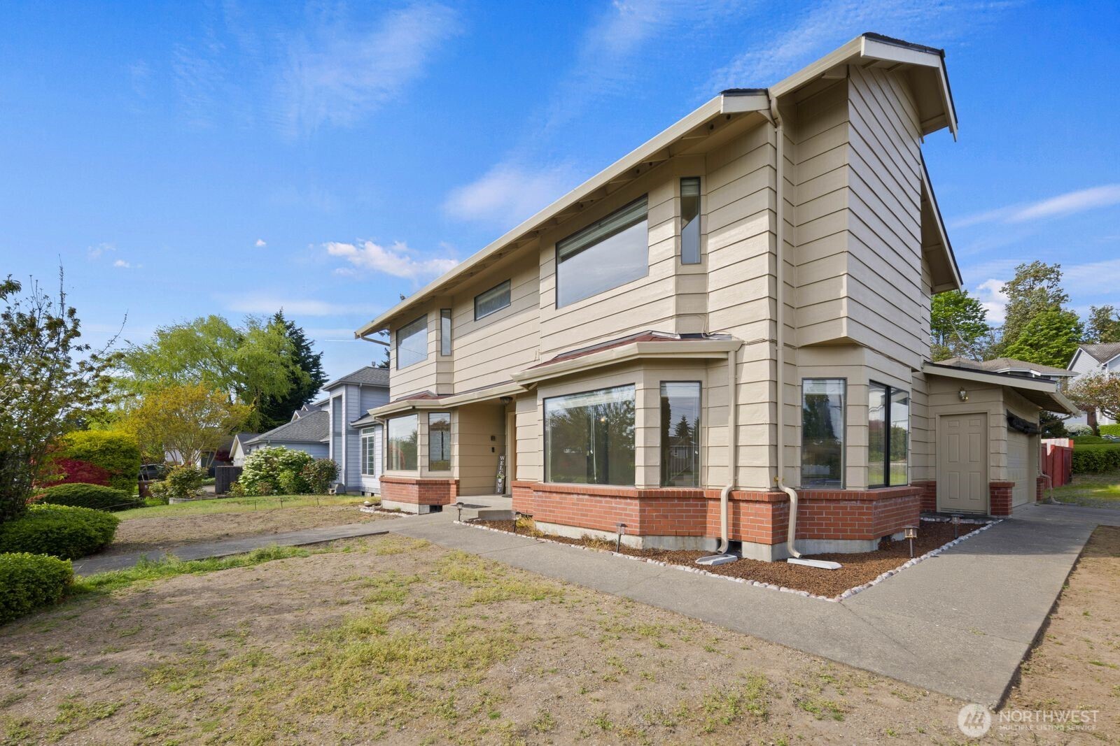 Alternate exterior angle highlighting corner windows, driveway access, and an additional exterior entry