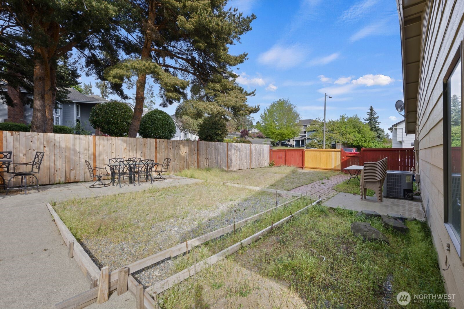 Rear exterior view showing siding, yard space, and patio access