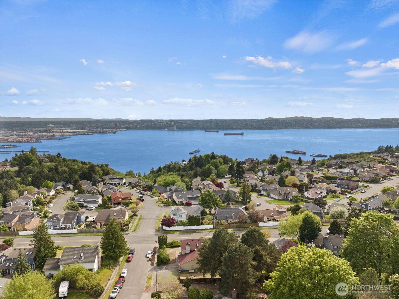 Wide aerial capturing the broader community and water views, helping buyers understand not just the home, but where it sits within the neighborhood.
