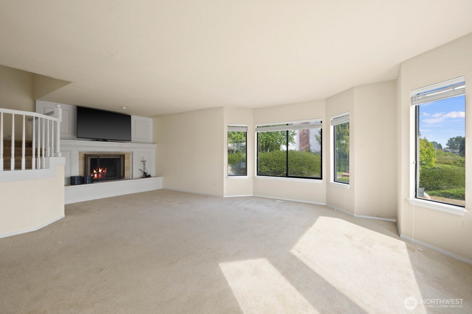 Open living space with multiple windows bringing in natural light and views of the surrounding exterior