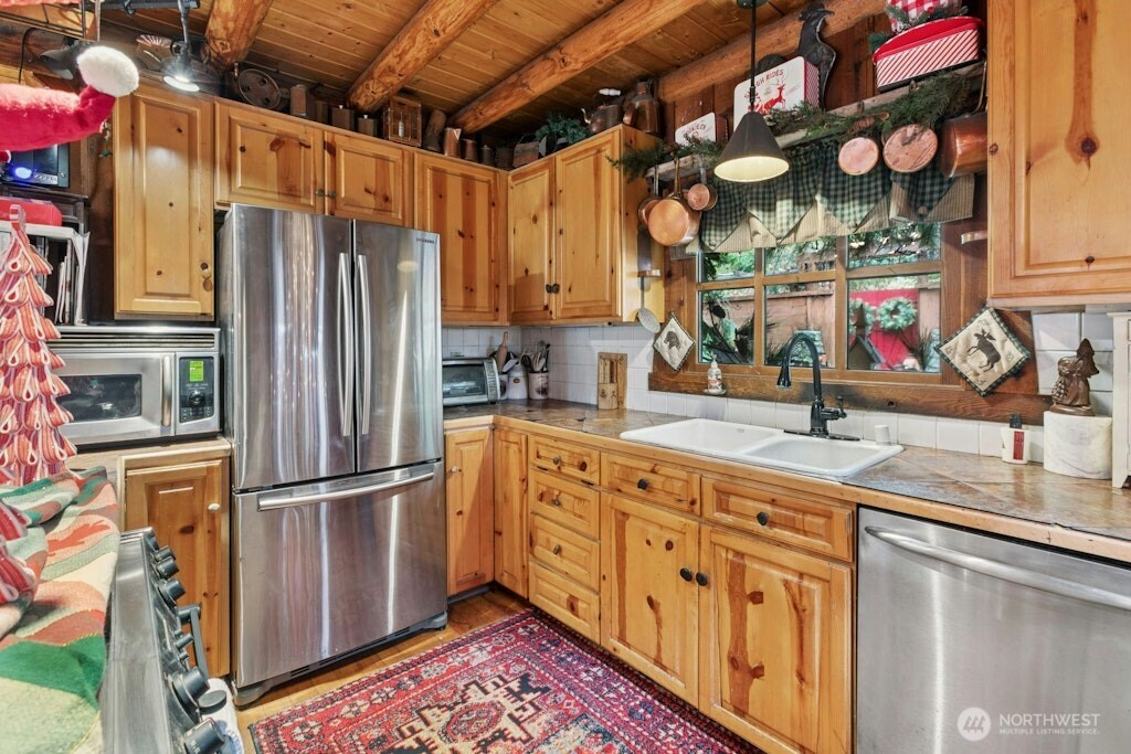 Kitchen with stainless steel appliances and original wood flooring.