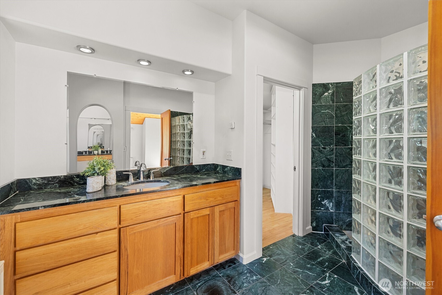The primary bathroom also has a spacious walk-in closet with built-in shelving.