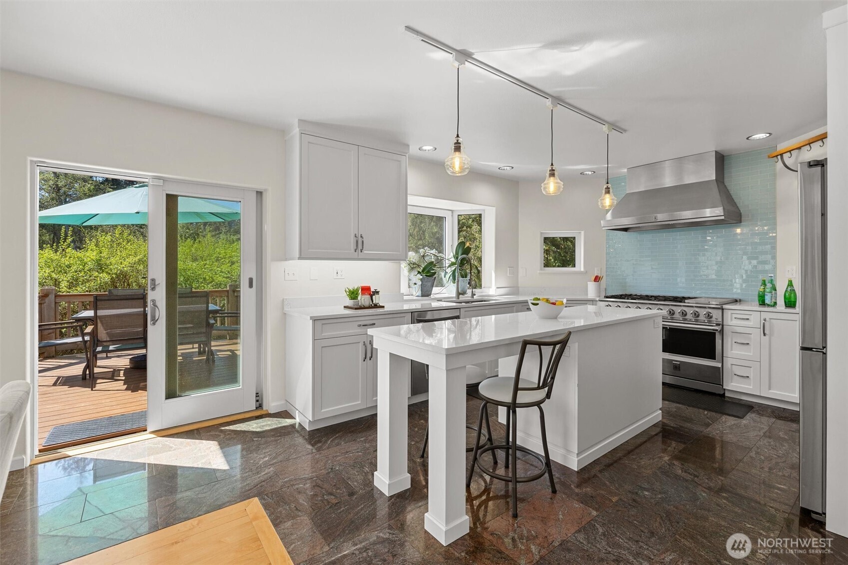 Remodeled kitchen with center island and bay windows overlooking the creek below.