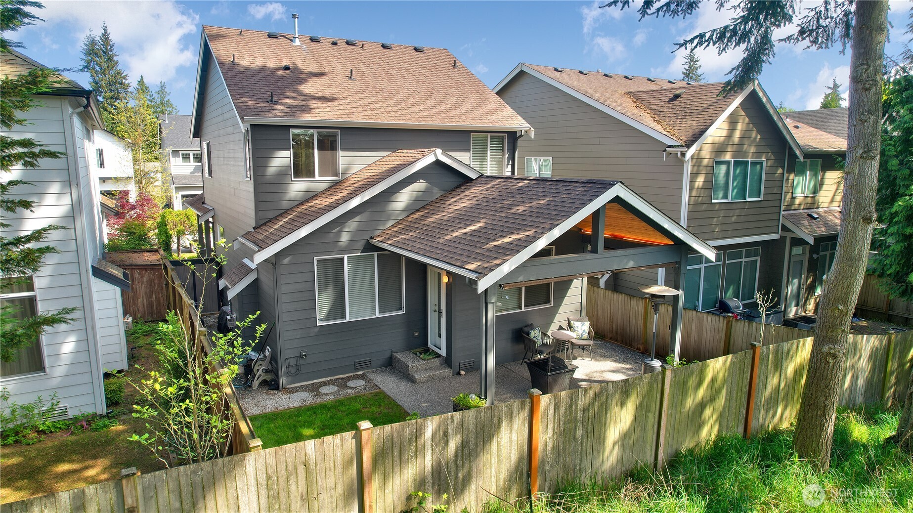 Private, low-maintenance backyard retreat featuring a fully fenced yard with a covered patio—perfect for outdoor dining, relaxing, and entertaining year-round. The patio provides sheltered seating, while the surrounding greenery and mature trees create a peaceful, private setting. Thoughtfully designed for easy upkeep, this backyard offers the ideal balance of comfort, functionality, and privacy just steps from the main living area.