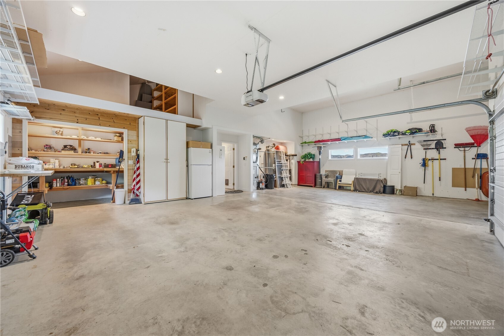 Expansive garage featuring a massive RV/boat bay with high ceilings and oversized door, plus an additional two-car garage bay. Clean concrete floors and ample space for vehicles, storage, or workshop use.