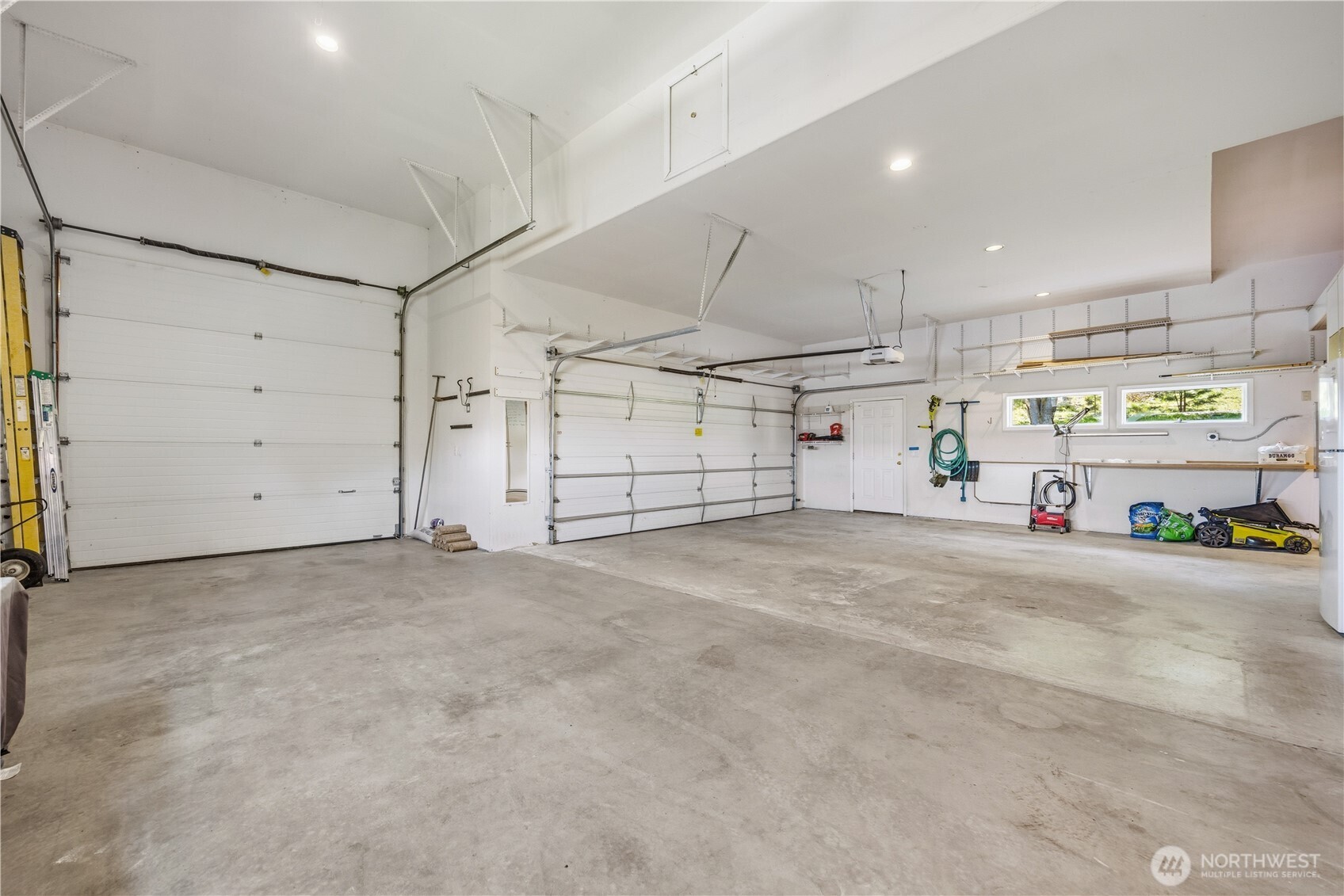 Expansive garage featuring a massive RV/boat bay with high ceilings and oversized door, plus an additional two-car garage bay. Clean concrete floors and ample space for vehicles, storage, or workshop use.