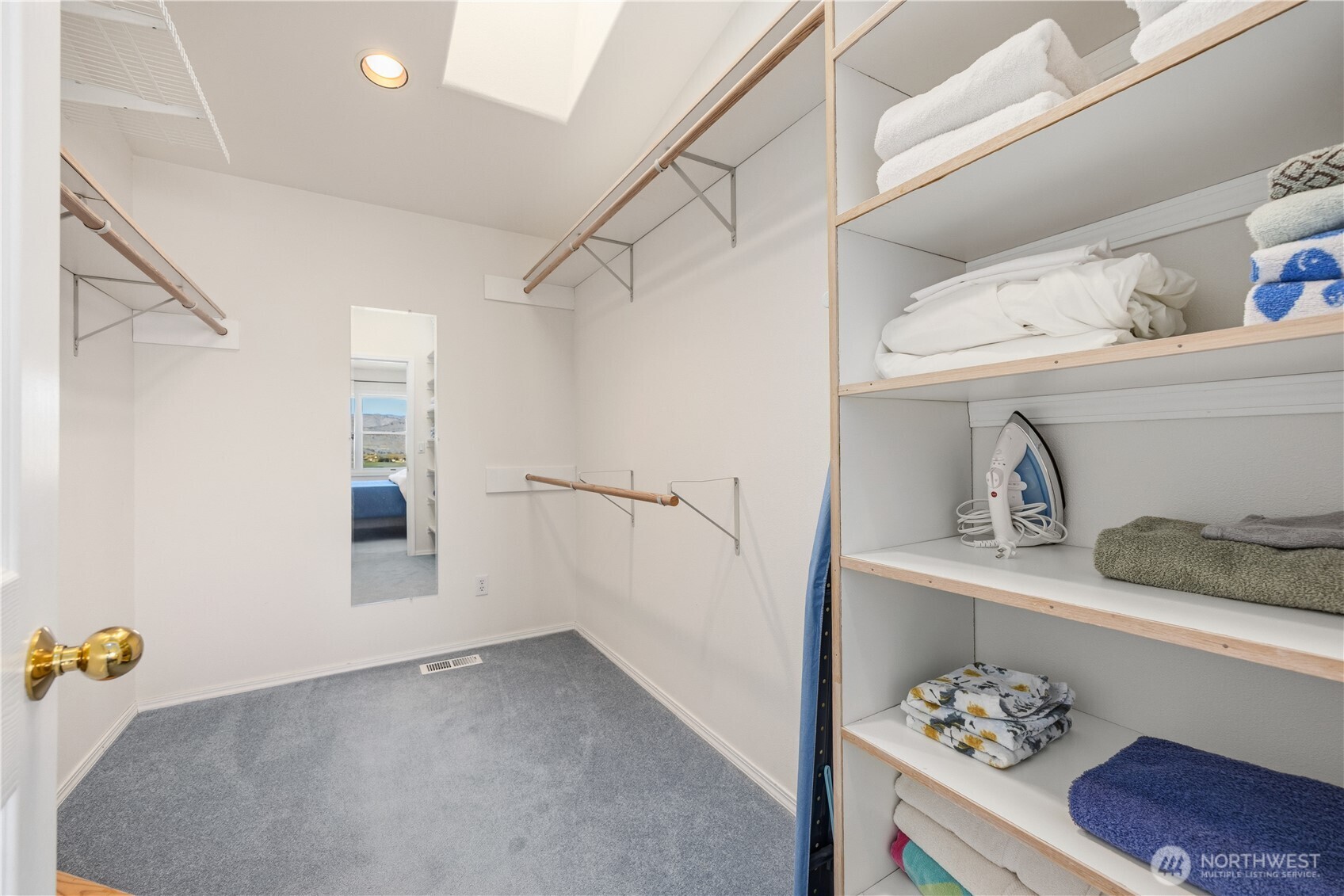 Primary walk-in closet with built-in shelving, hanging rods, and organized storage space. Clean, functional layout with ample room for clothing and accessories.