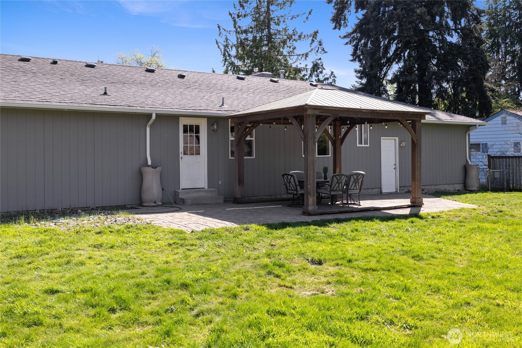 Large fully fenced back yard features gazebo and dog run area