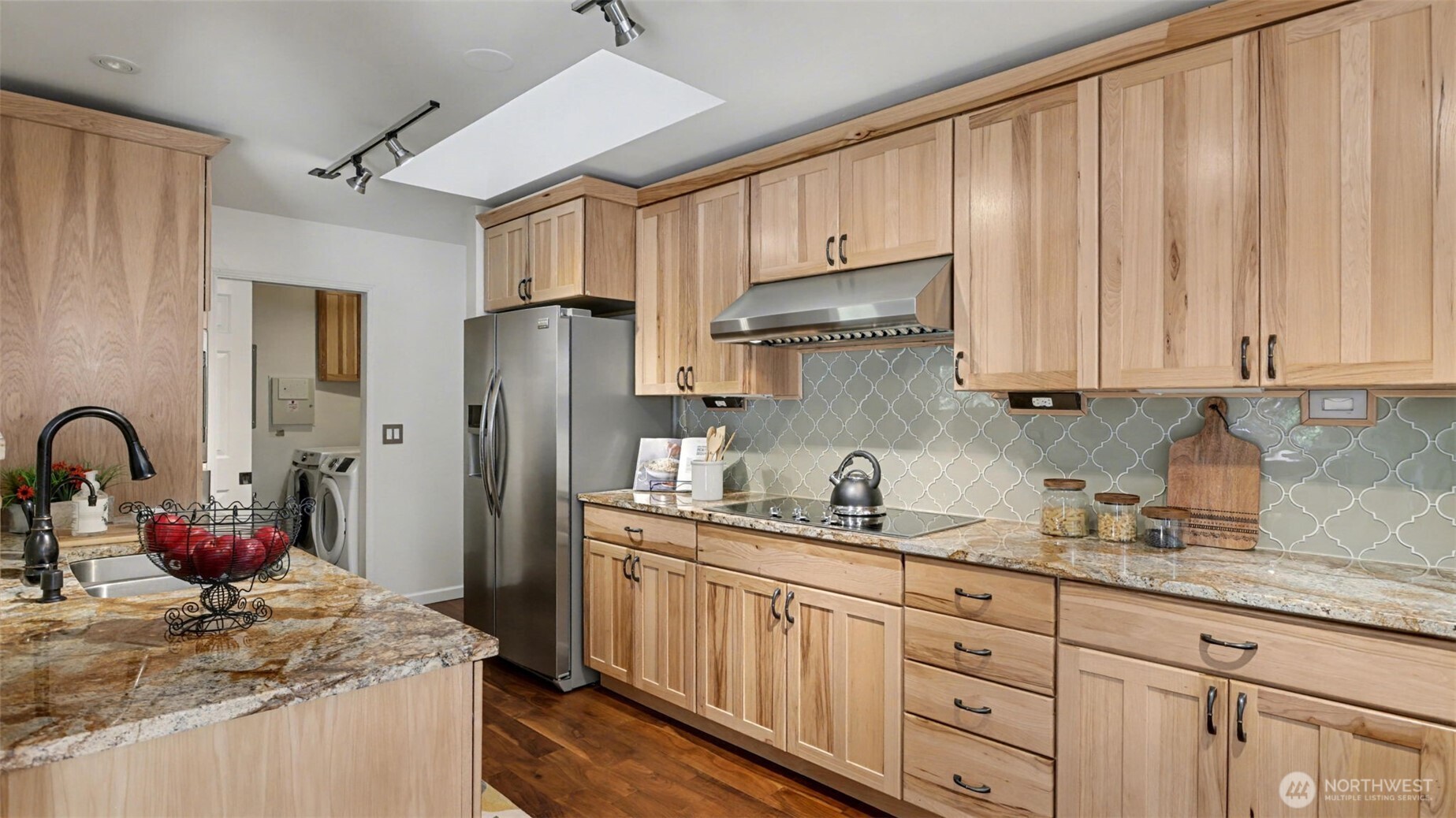 The kitchen features granite countertops, custom hickory cabinets, higher-end appliances, insta-hot, and a pull-out pantry—designed for both function and everyday living.