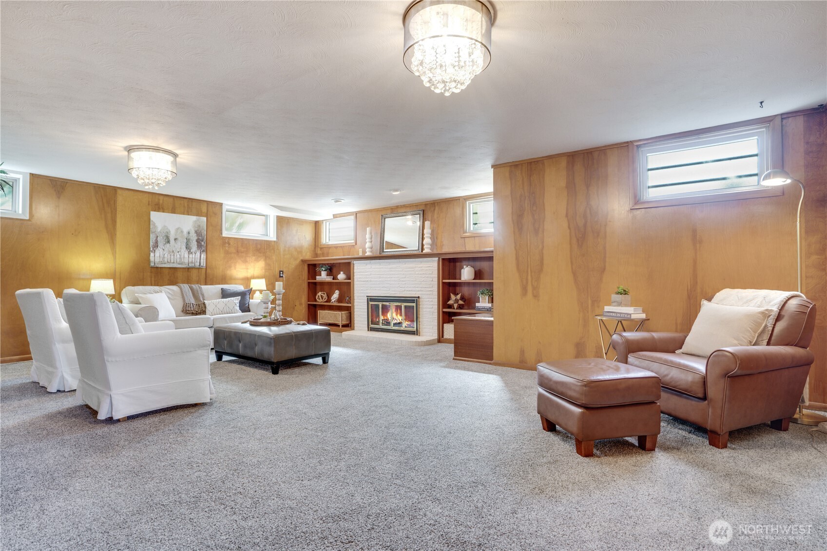 Large family room downstairs is charming.  Photo is edited to include fire. Seller has not made a fire here.