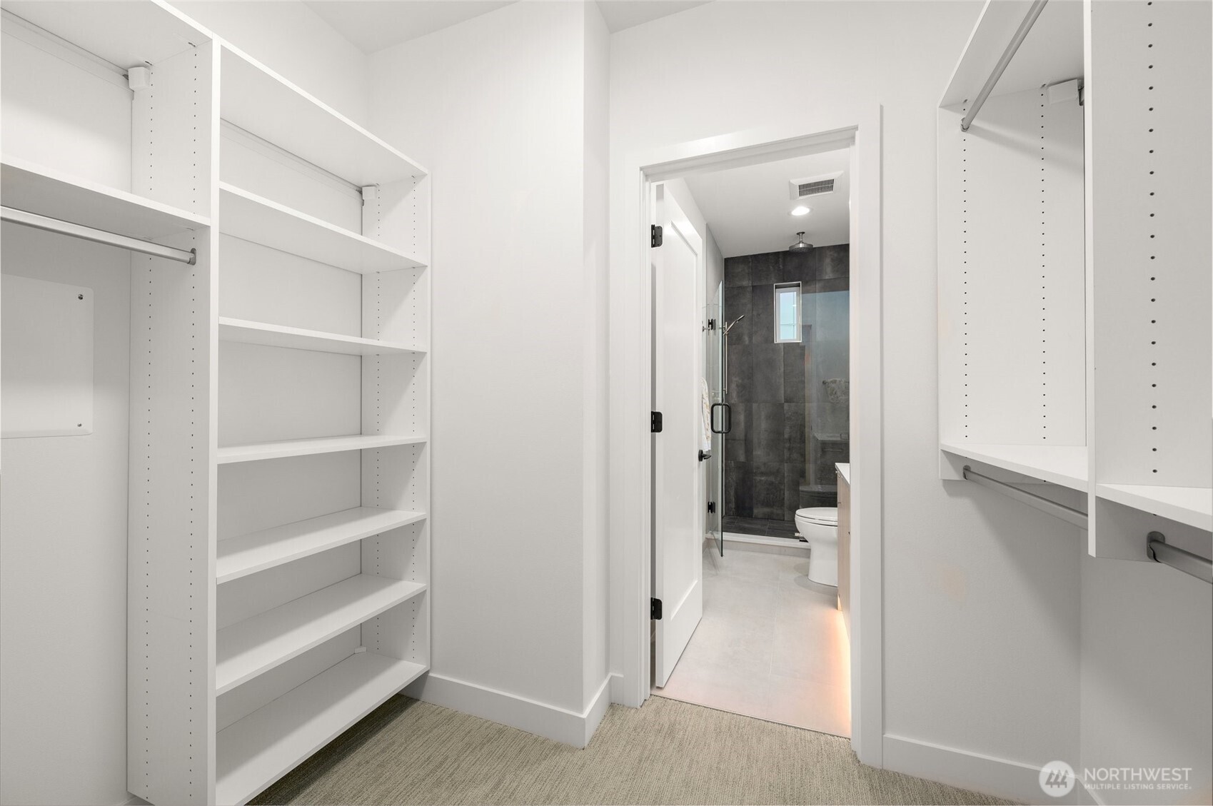 Walk-in closet with custom built-in shelving for optimal organization and storage.