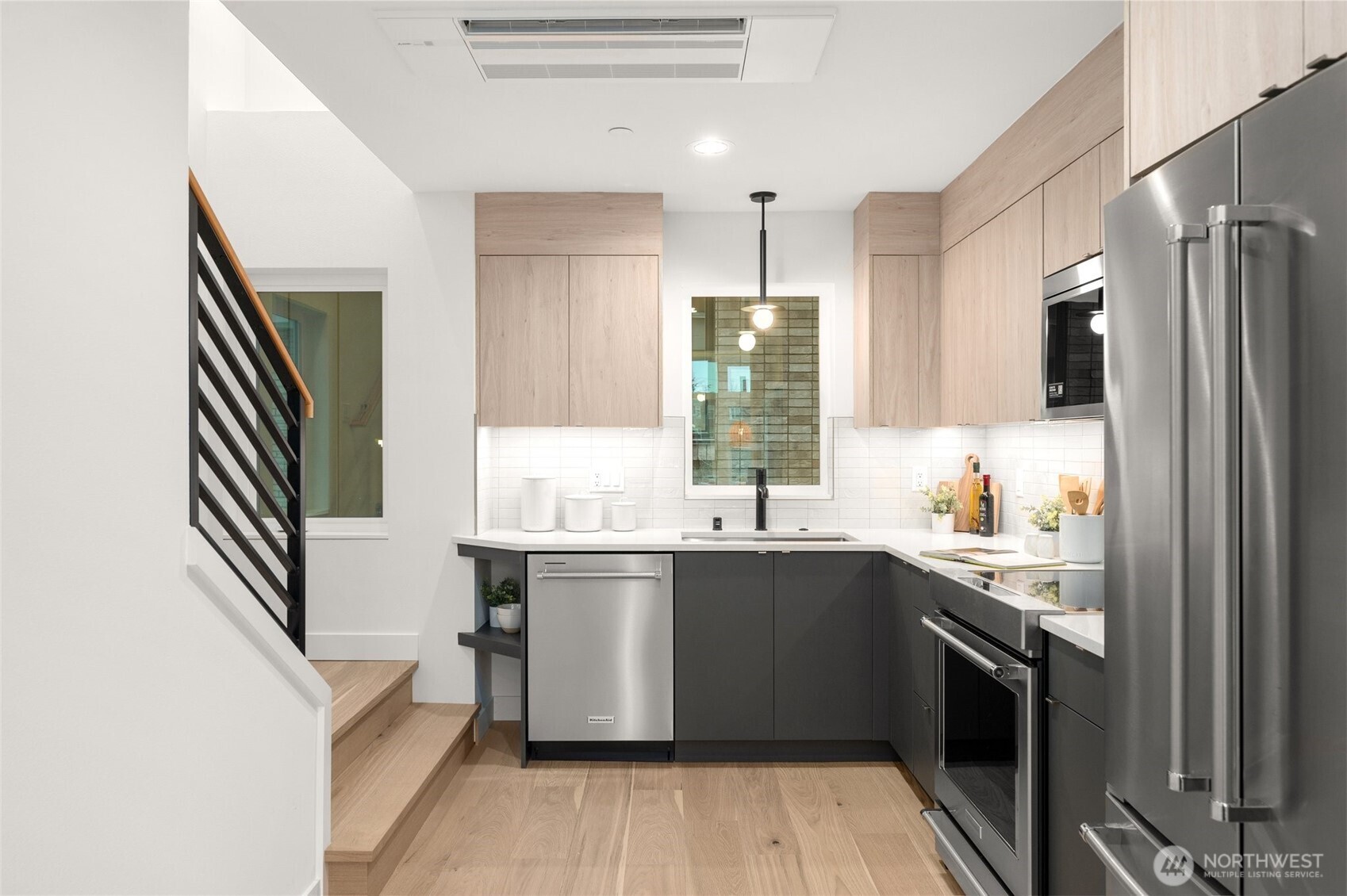Chef’s kitchen with sleek quartz countertops and brand-new stainless steel appliances.