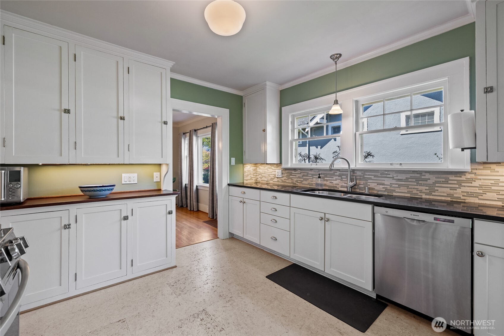 Double window over the sink with spacious counter, tile backsplash & great storage.