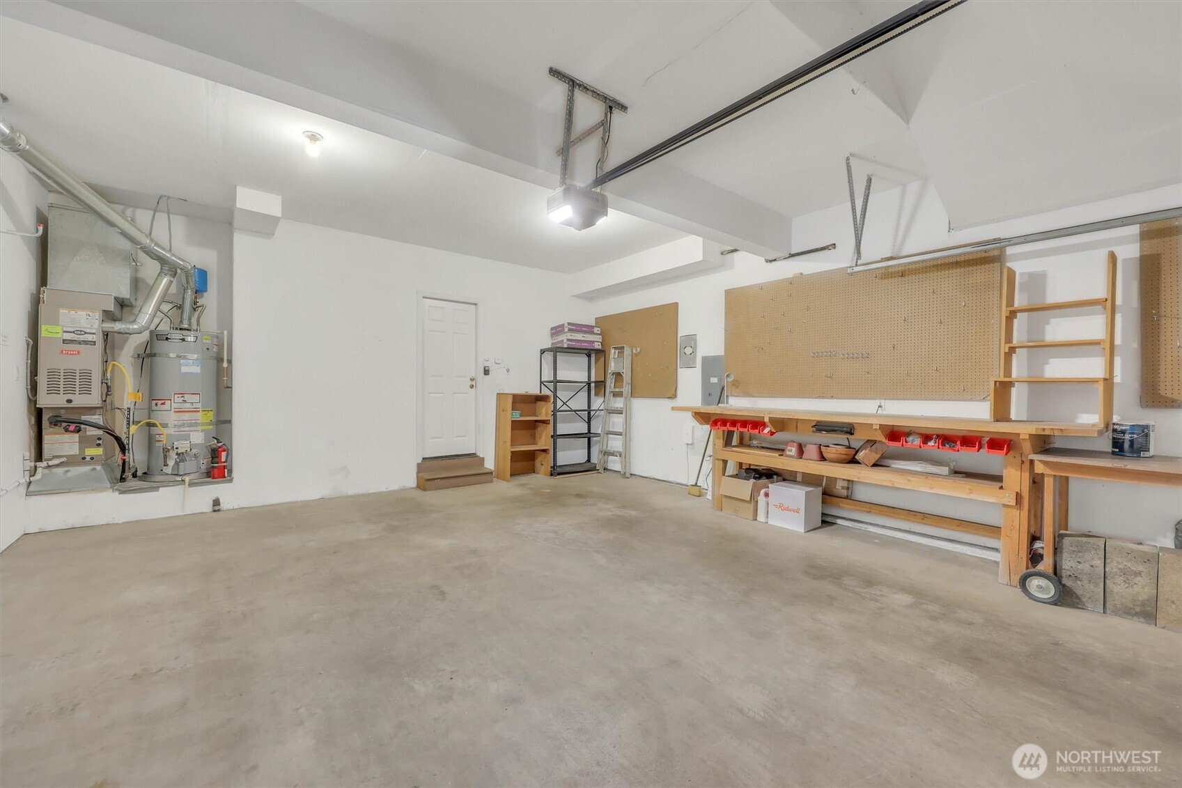 Large 2 car garage with shelving and work bench.