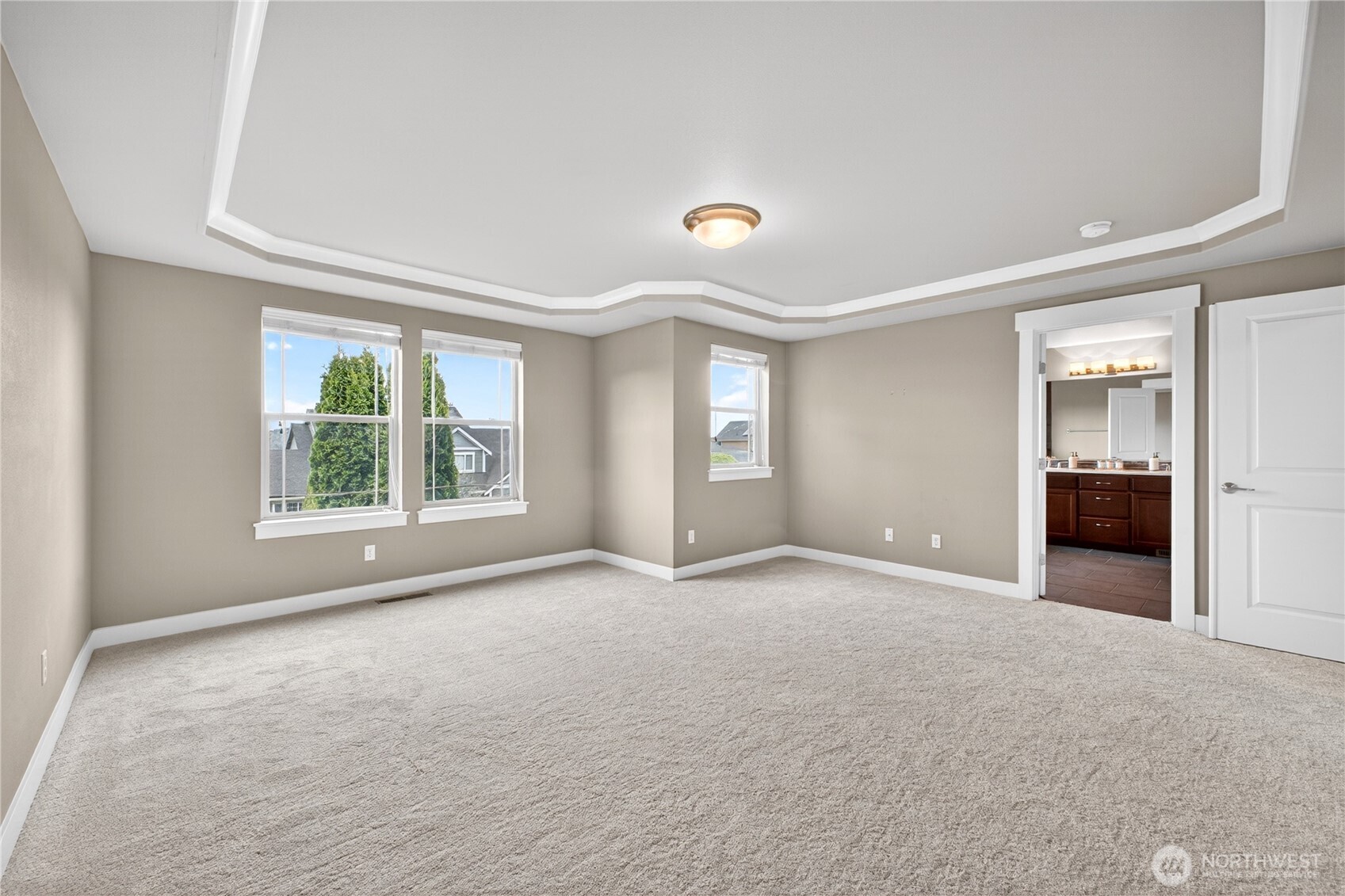 Luxurious primary suite features a coved ceiling, beautiful morning and evening views, a private ensuite bath, and a spacious walk-in closet.