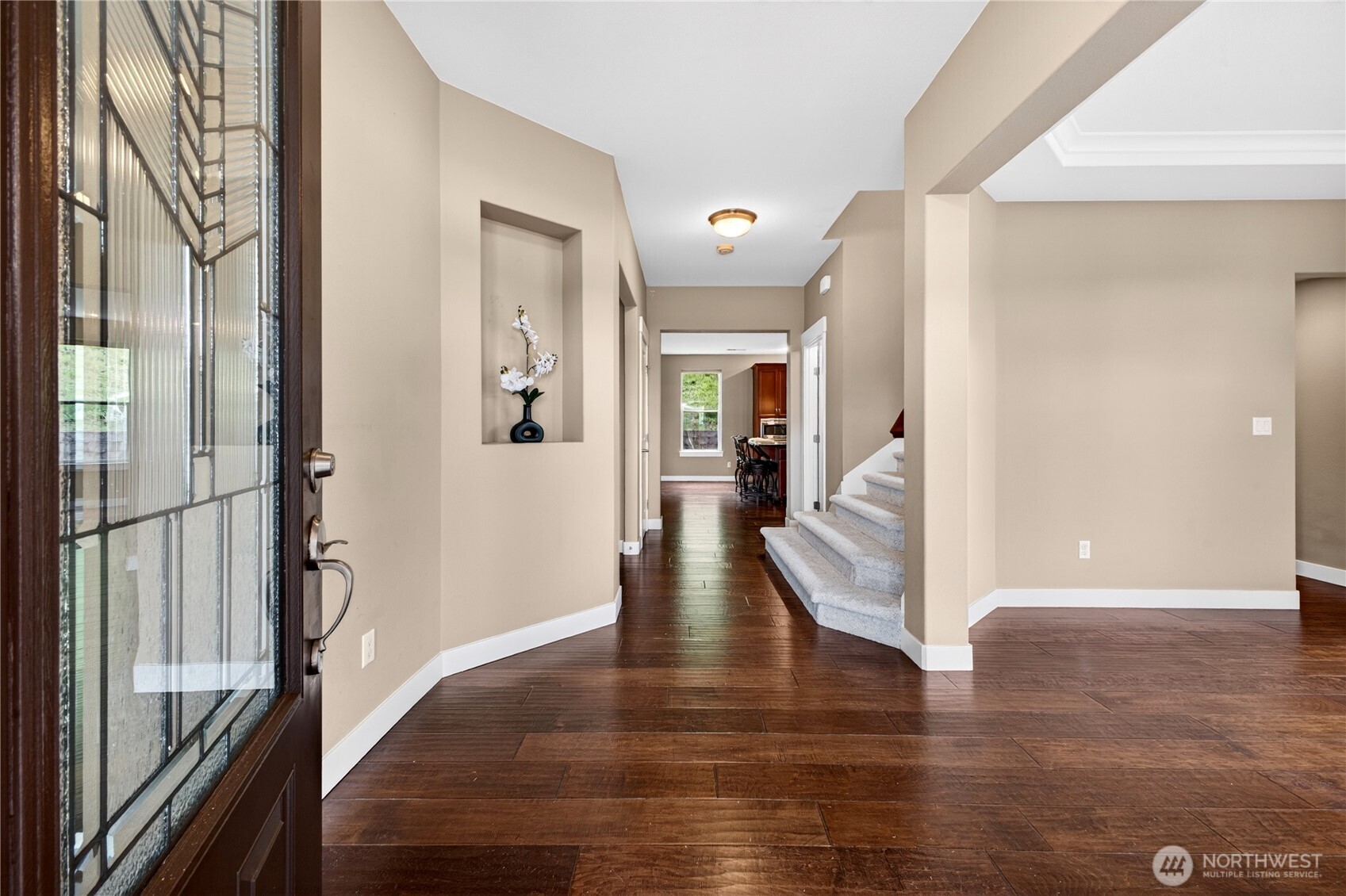 Elegant entry welcomes you with hardwood flooring, a display shelf, soaring ceilings, and a spacious coat closet