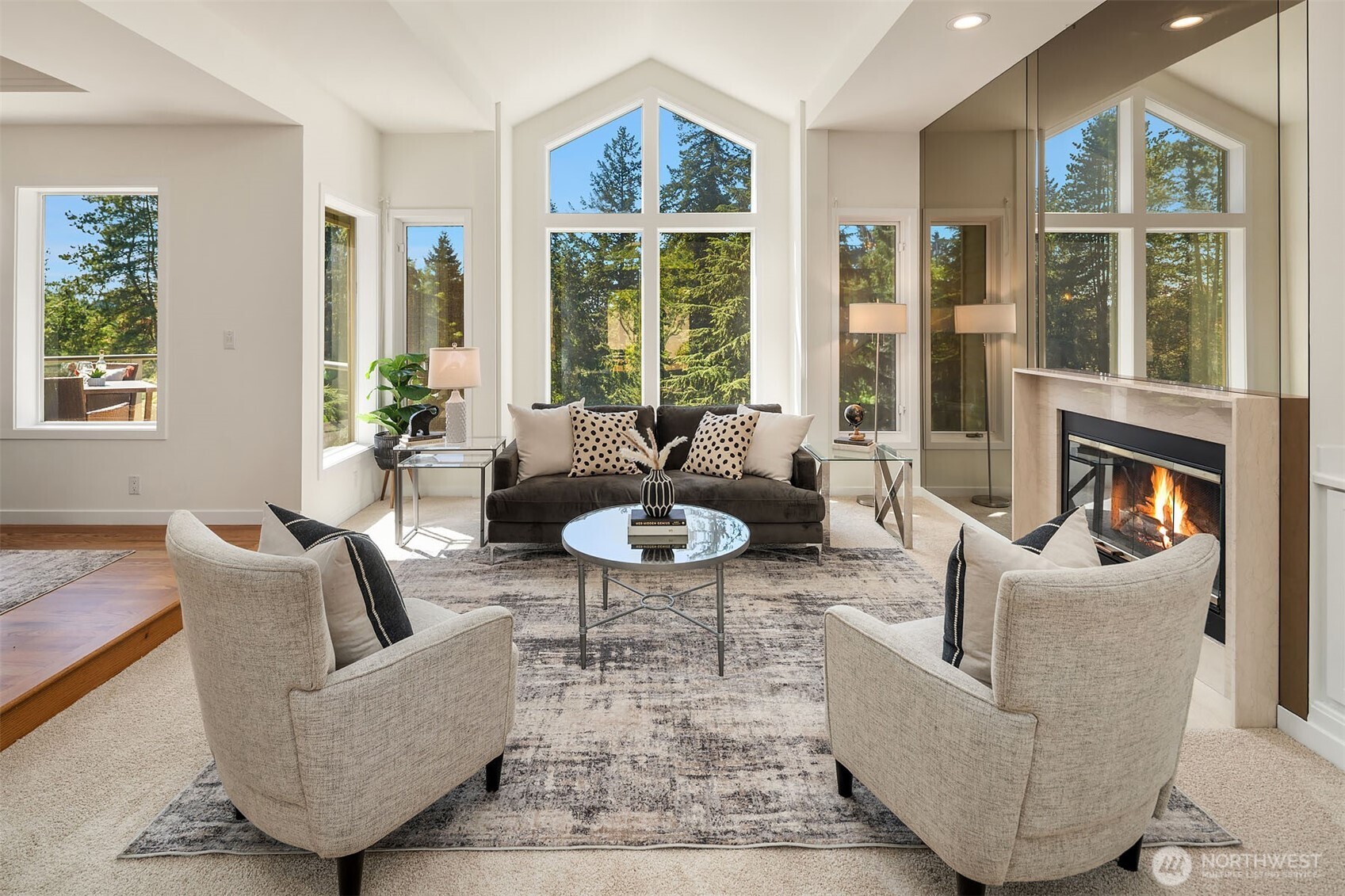 Living room with new carpeting, high-ceilings and wall of windows that bring the outdoors in