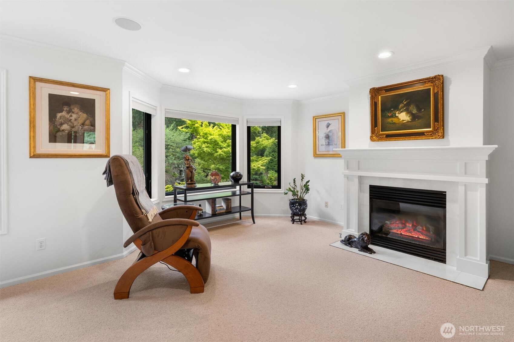 Seating area in primary bedroom with gas fireplace and private garden views.