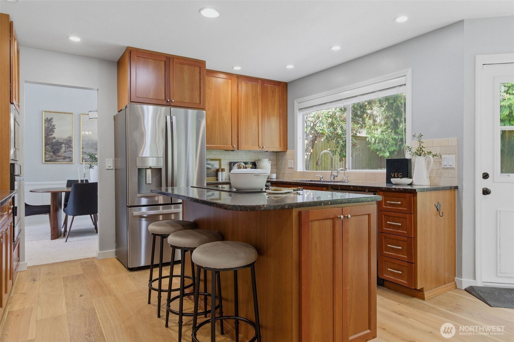 Main floor suite features a bright sitting room with custom cabinets, a large bedroom with closet built ins, and a stunning 3/4 bath - ideal for multigenerational living or extended guest stays.