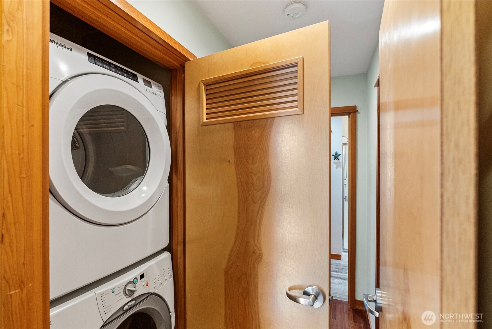 Stacked laundry units are located in the primary bedroom