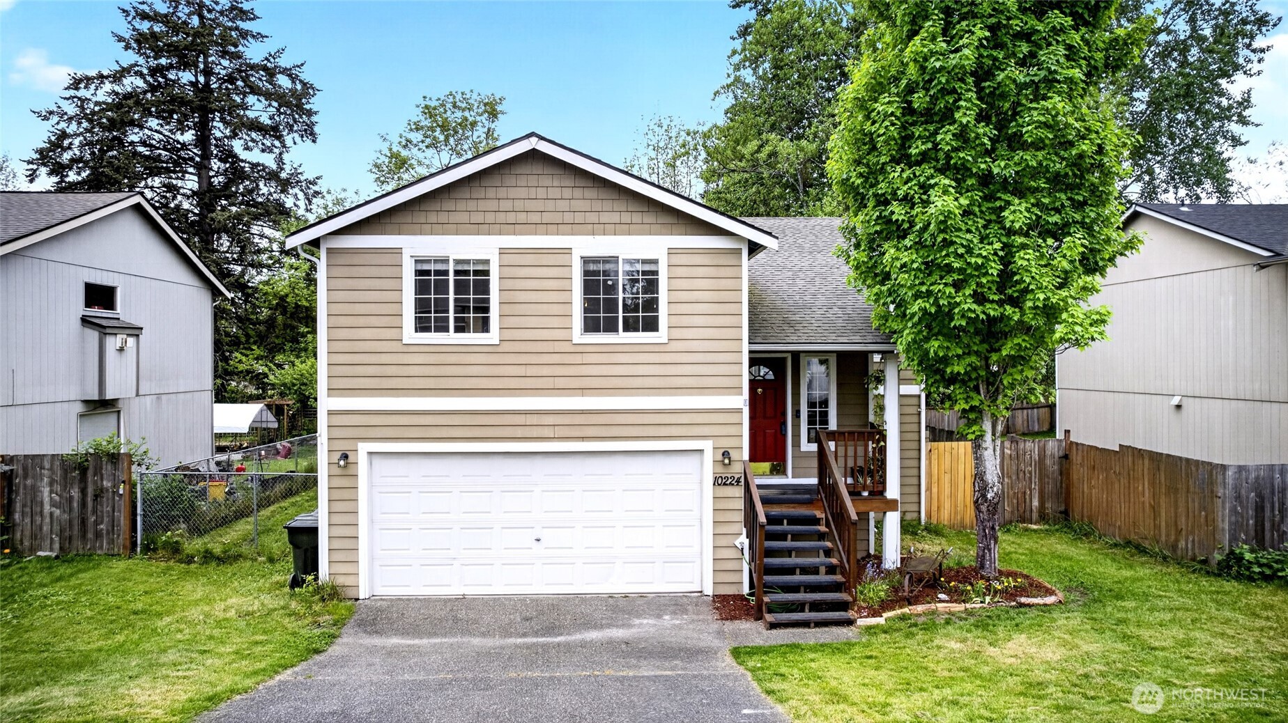 Front view with updated landscaping newer deck and large 2 car garage
