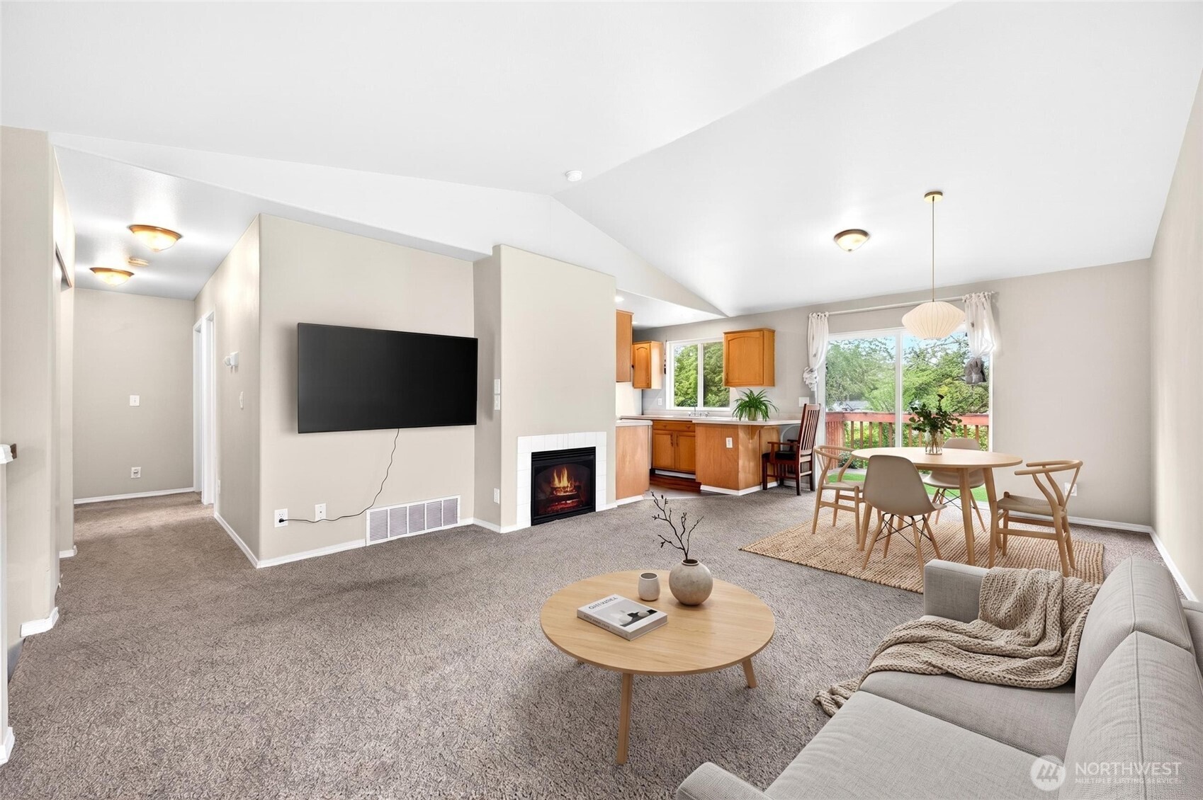 Virtually staged large great room off main level with vaulted ceilings gas fire place and light bright colors