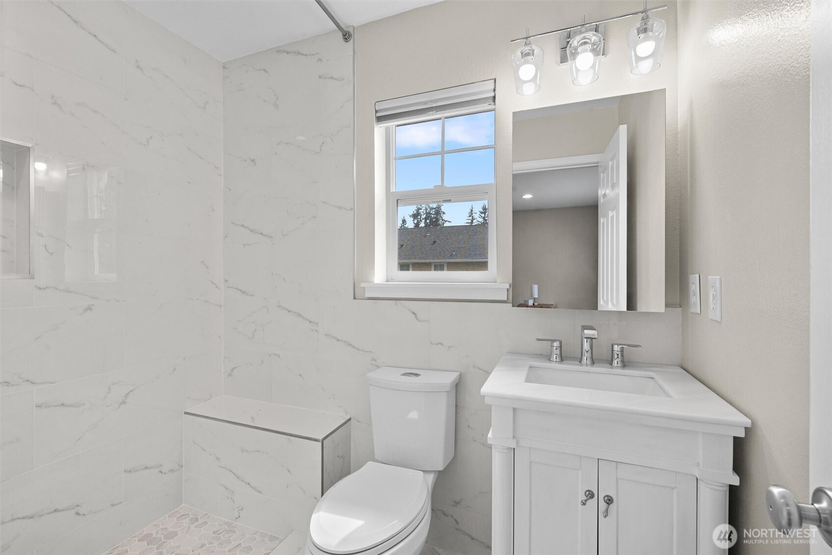 The primary bathroom has also been remodeled with a timeless, neutral palette. The step-in shower is spacious!
