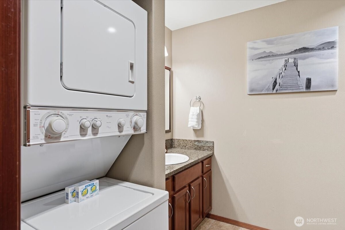 Dedicated laundry setup with stackable washer and dryer enhances long-term usability and convenience.