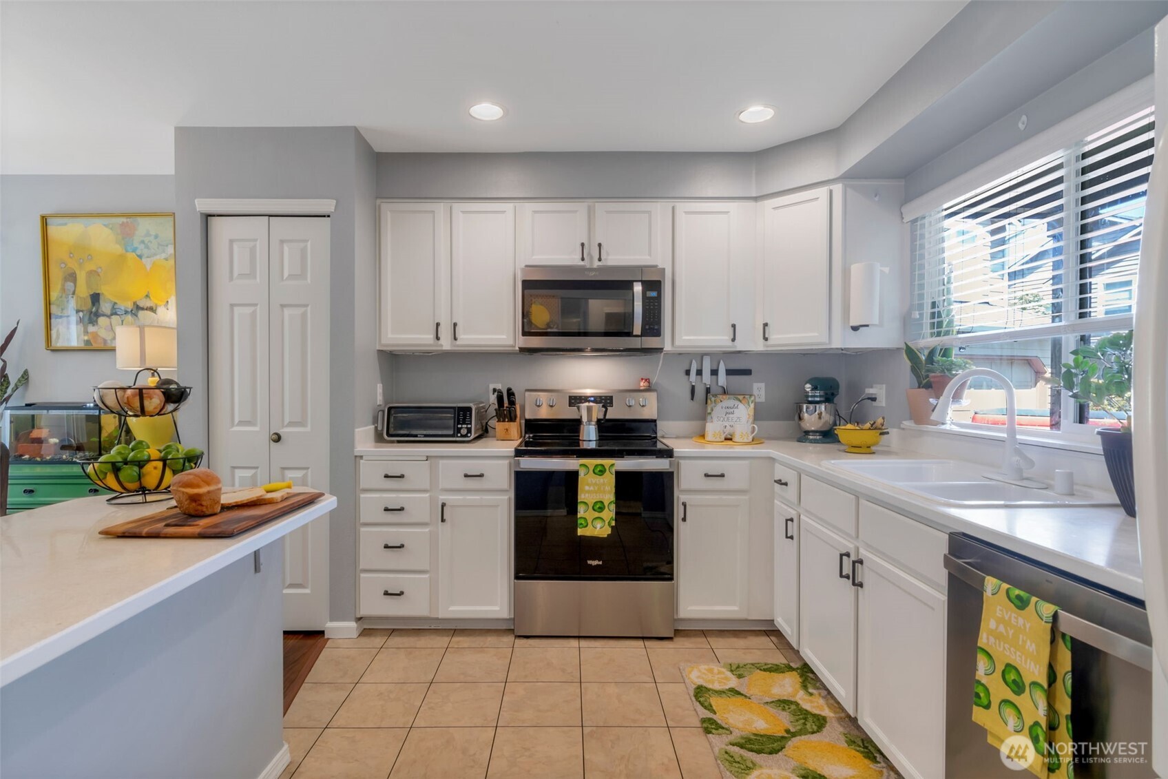 Bright eat-in kitchen with island/bar & newer SS appliances. Microwave & Stove replaced in 2023. 3-rack dishwasher replaced in 2025.